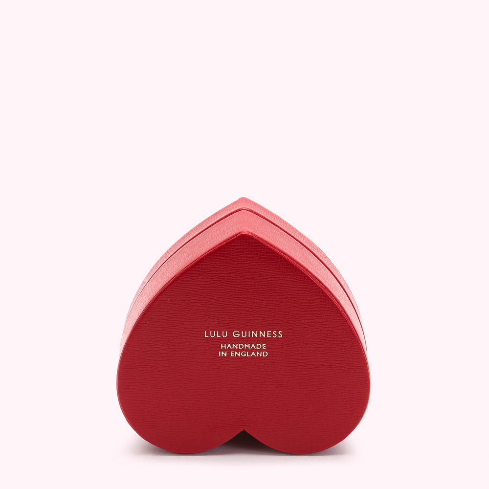 Red heart-shaped box with "Lulu Guinness Handmade in England" in gold lettering.
