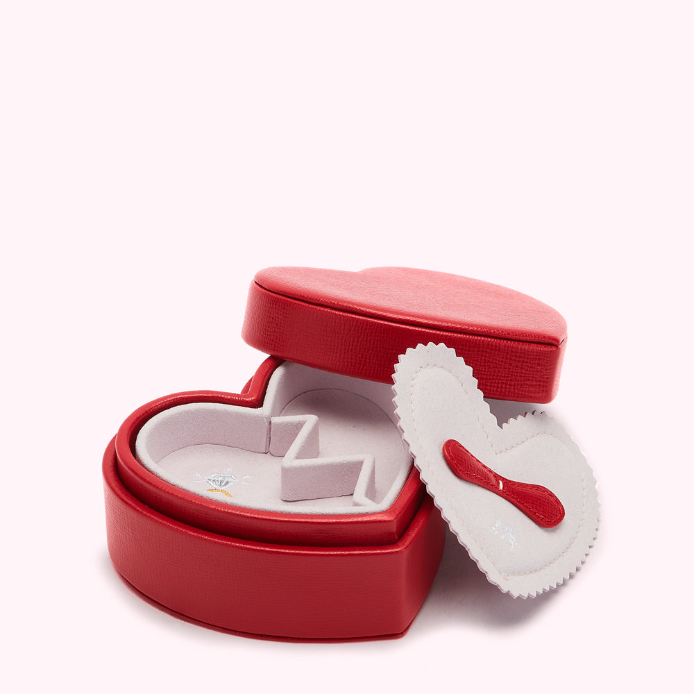 Red heart-shaped jewellery box open to reveal a pink velvet interior with compartments.