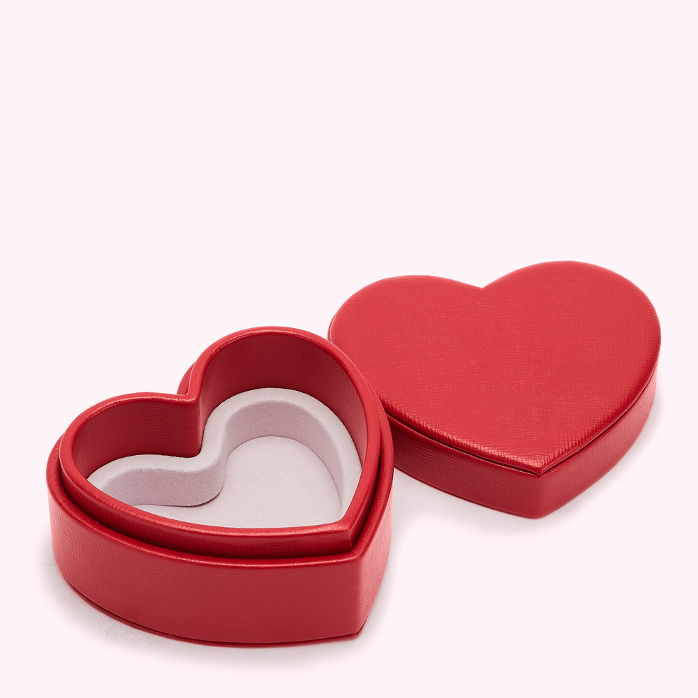 Red heart-shaped jewellery box open on a white background.
