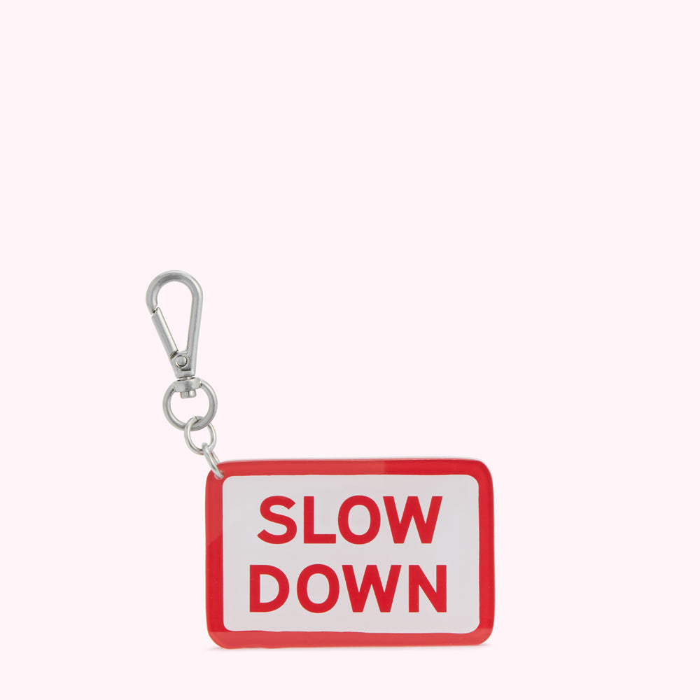 Red and white keychain with the words "SLOW DOWN" in red lettering.
