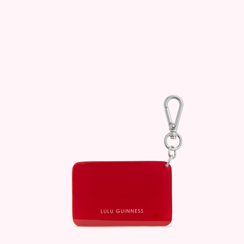 Red Lulu Guinness keyring against a white background.
