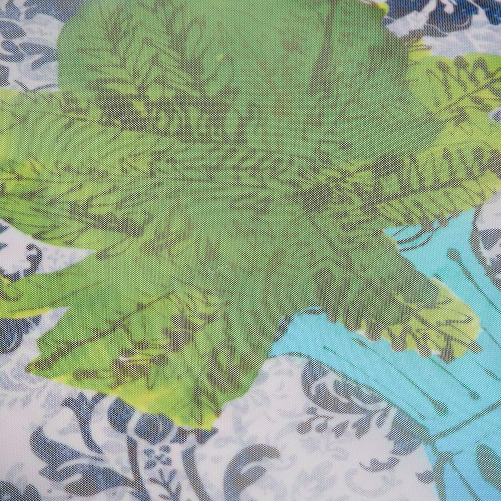 Close-up of sheer fabric with a green leafy print overlaid on a white background with a damask pattern.