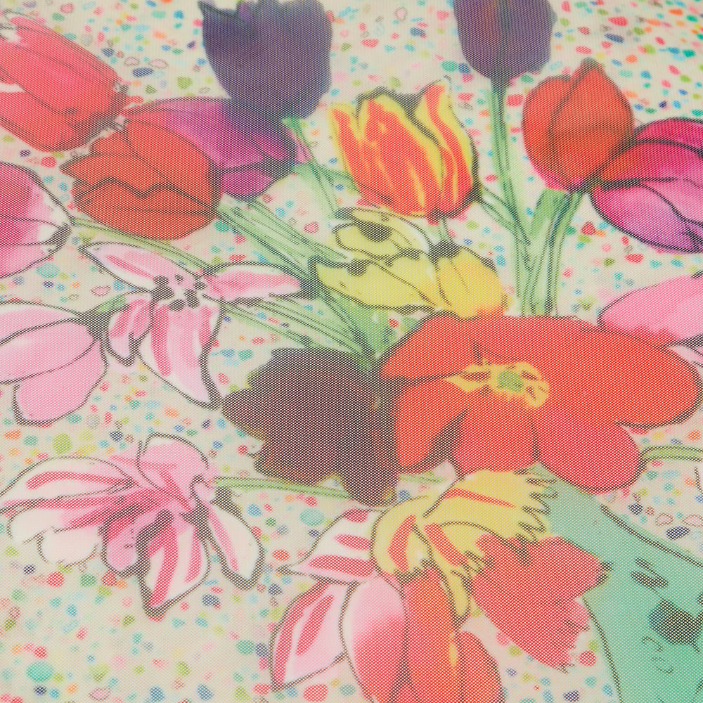Close-up of a colorful floral print on sheer fabric with a speckled off-white background.
