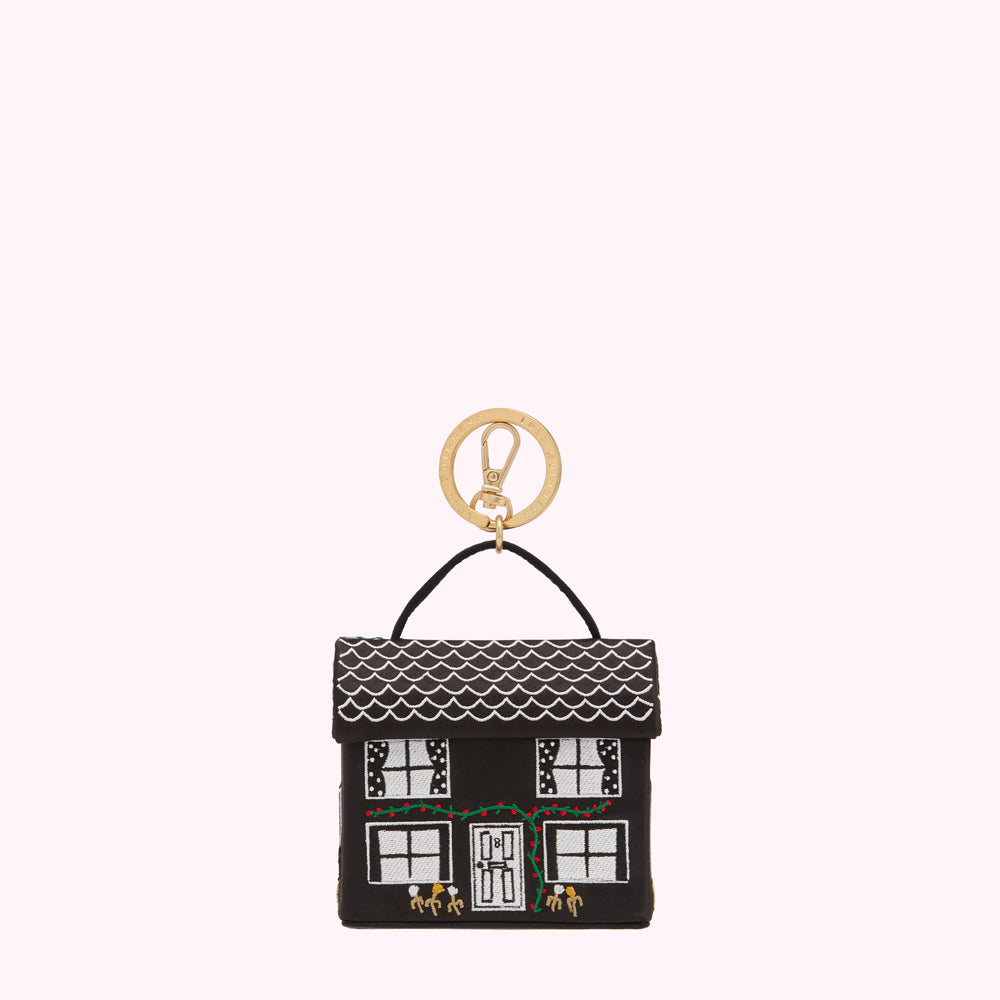 Black house-shaped keyring with white details and gold ring.
