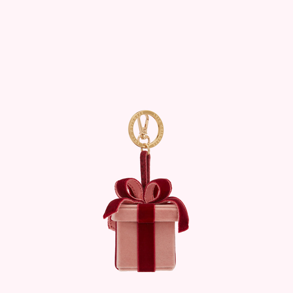 Pink velvet gift box-shaped keychain with a burgundy velvet ribbon and gold clasp.
