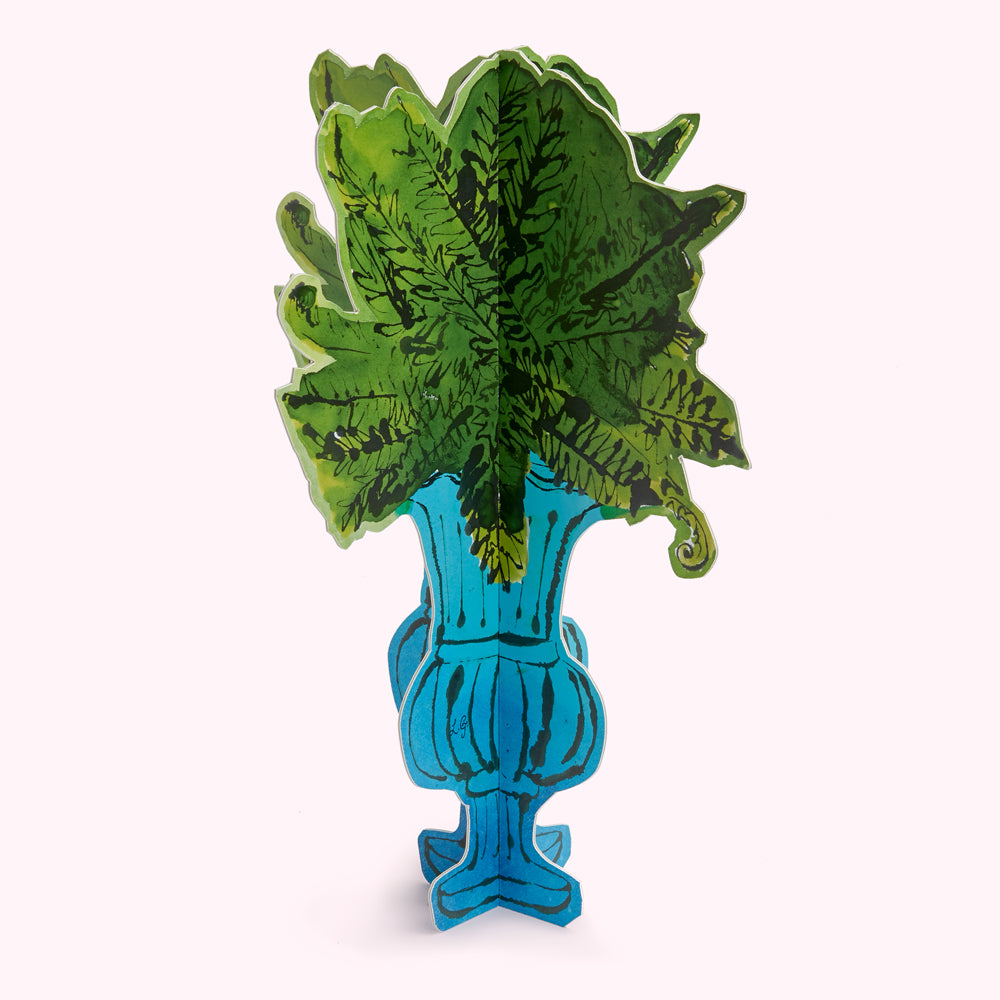 A teal blue urn filled with stylized green ferns, rendered as a paper cutout.