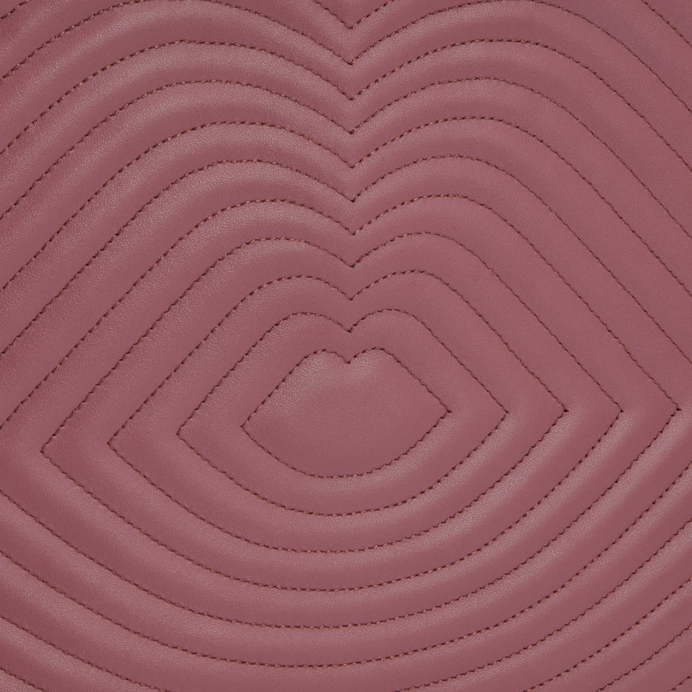 Close-up of mauve quilted leather with a repeating heart pattern.
