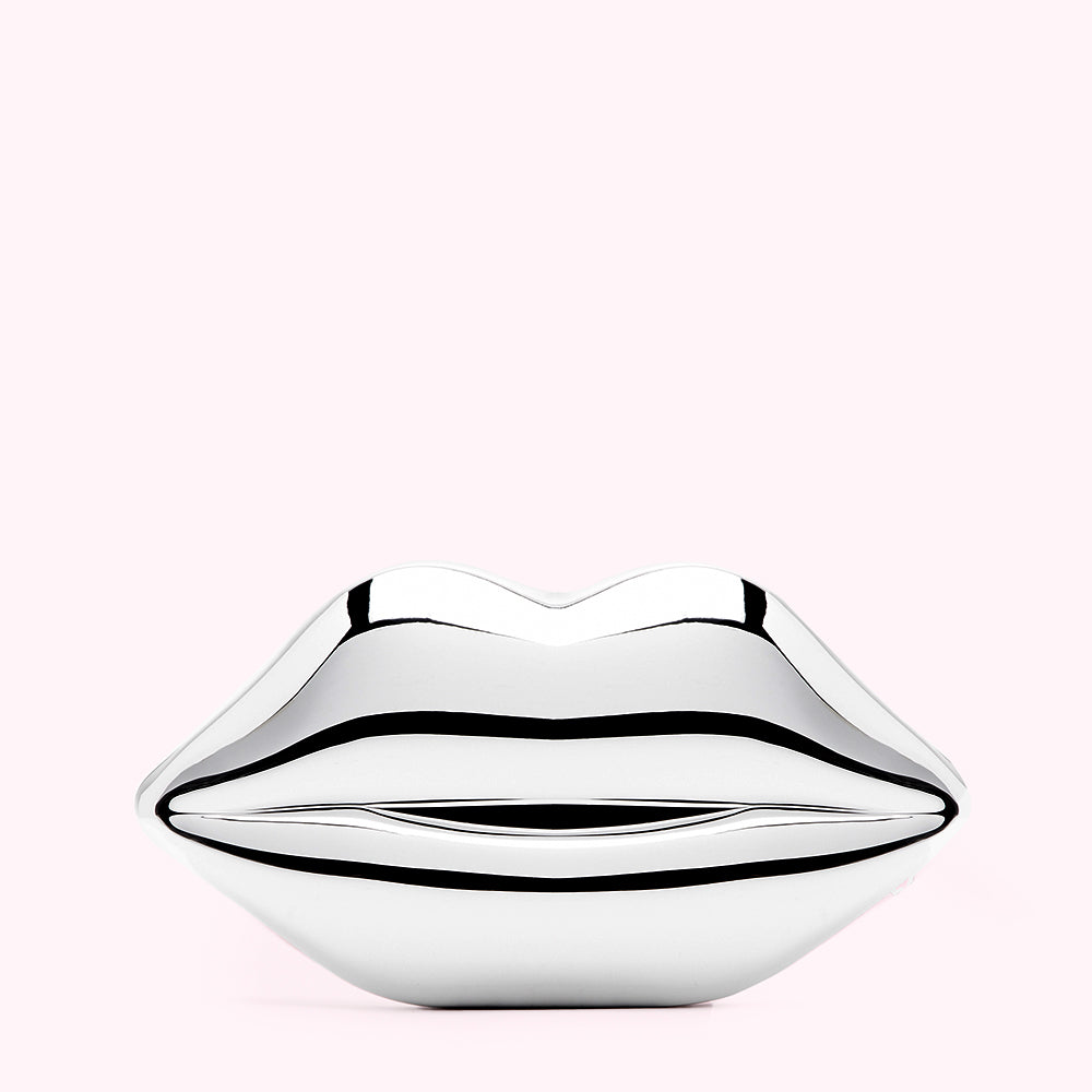 Silver lips sculpture against a light pink background.
