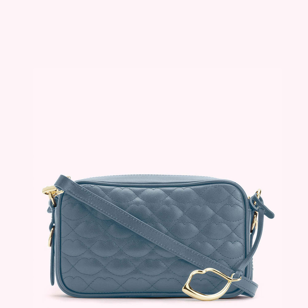 A dusty blue quilted crossbody bag with a gold clasp.
