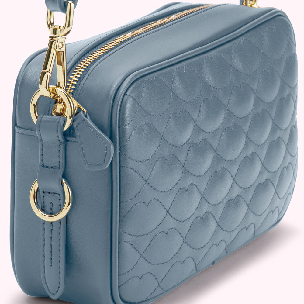 Dusty blue quilted crossbody bag with gold hardware.
