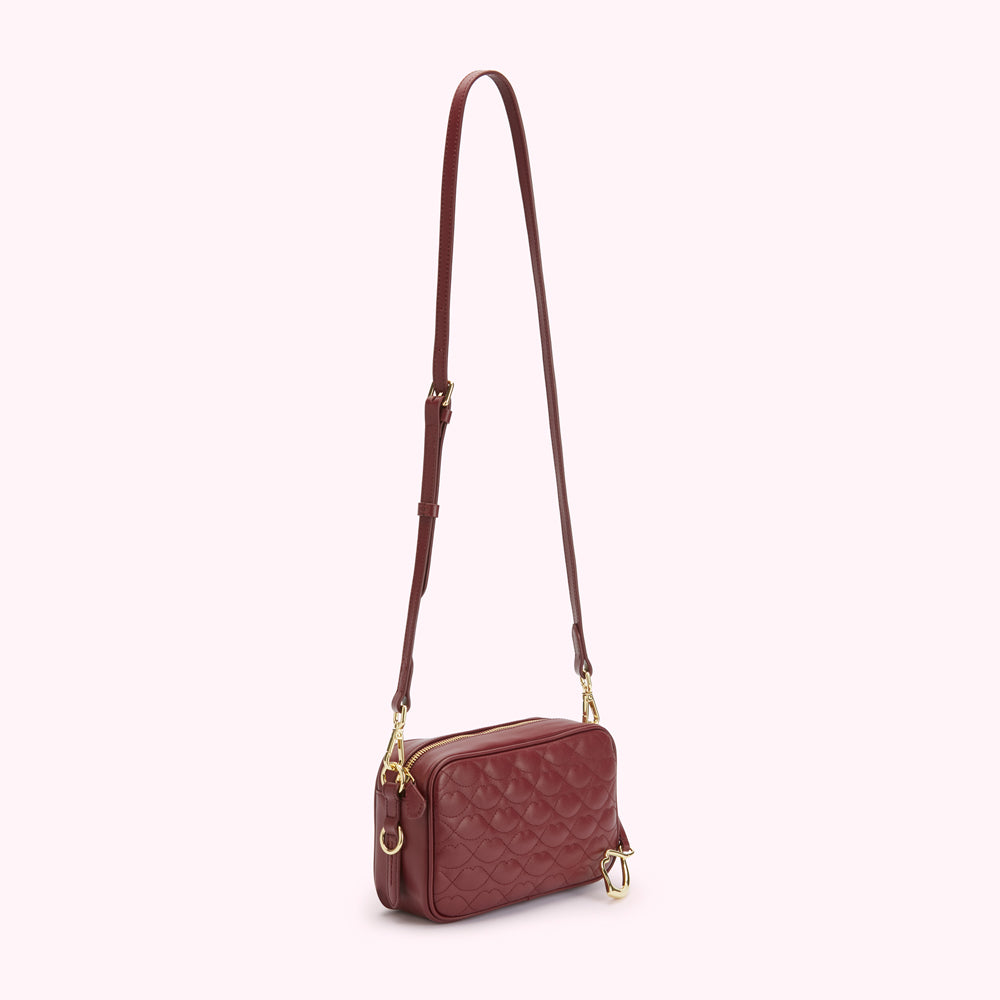 Burgundy quilted crossbody bag with gold hardware.