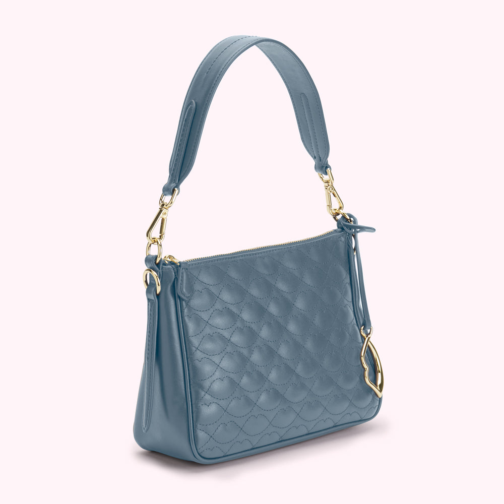 A dusty blue quilted shoulder bag with gold hardware.
