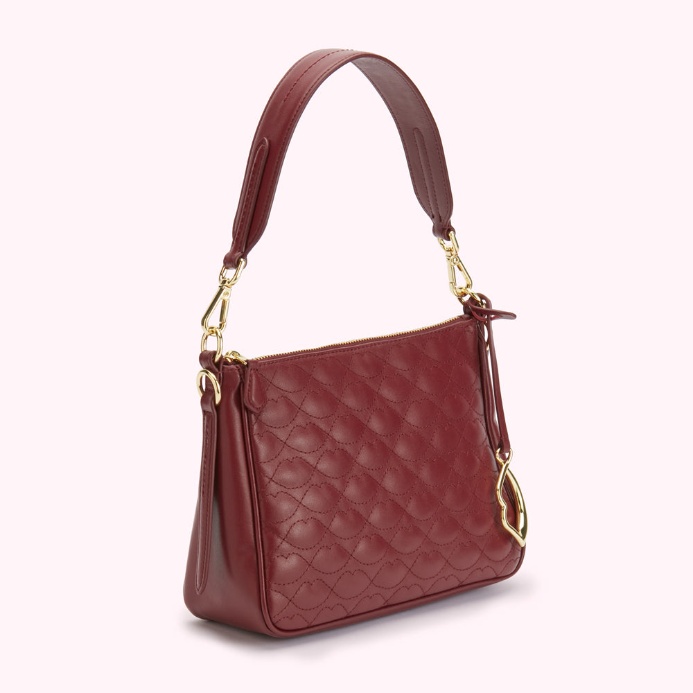 A burgundy quilted leather handbag with gold hardware.
