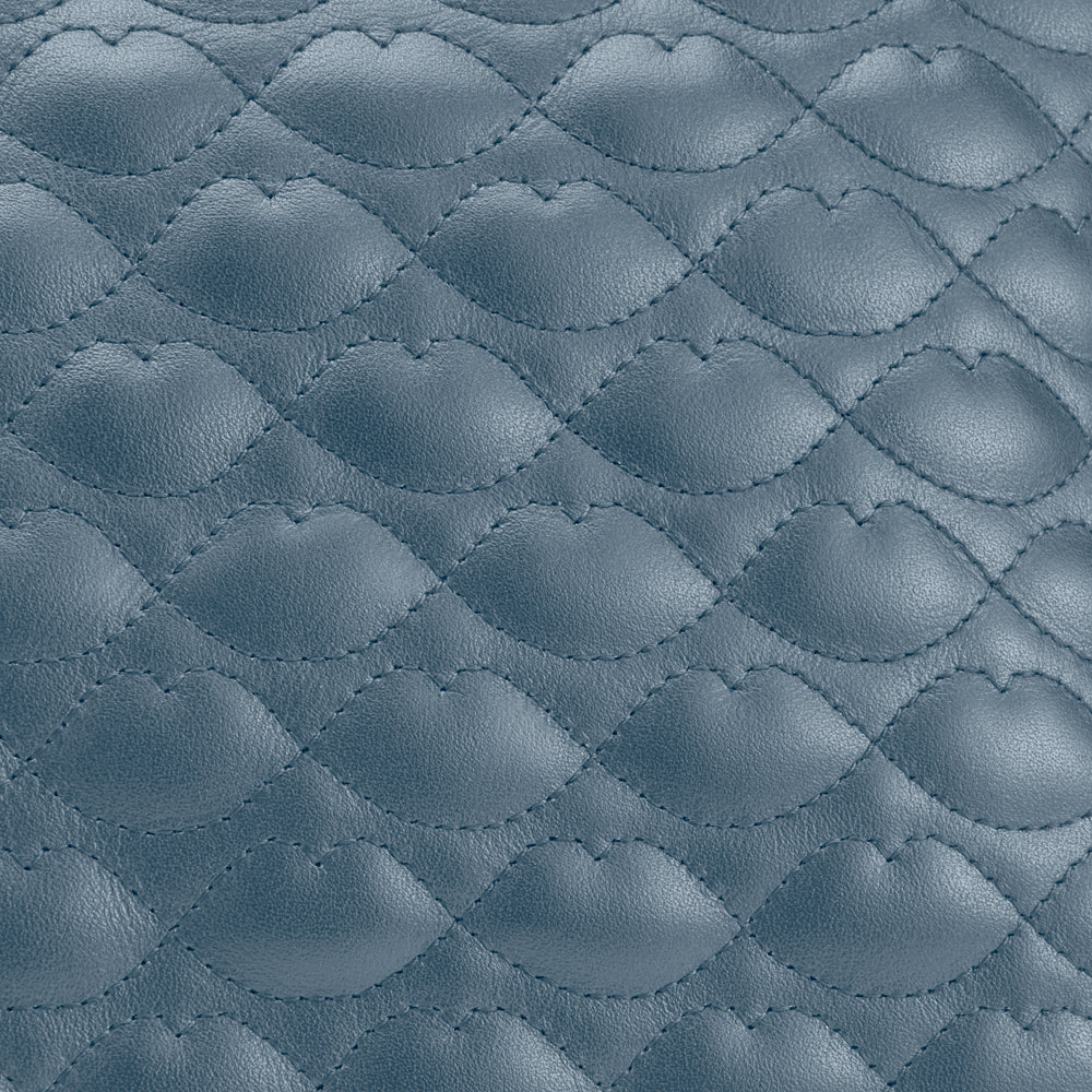 Close-up of quilted, blue leather texture.
