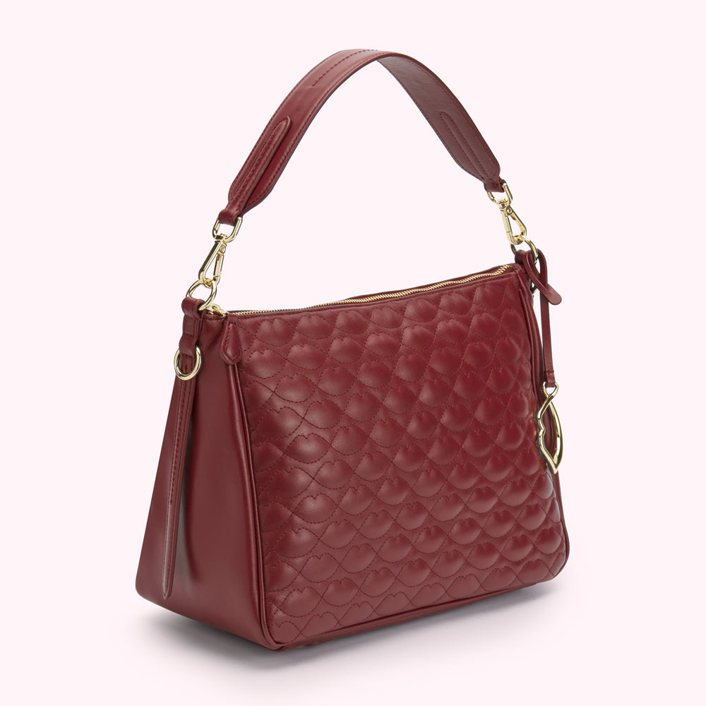 Burgundy quilted leather hobo bag with gold hardware.
