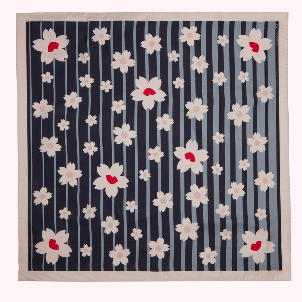 Silk scarf with a navy blue and light blue striped background and a pattern of stylized pink and red cherry blossoms.