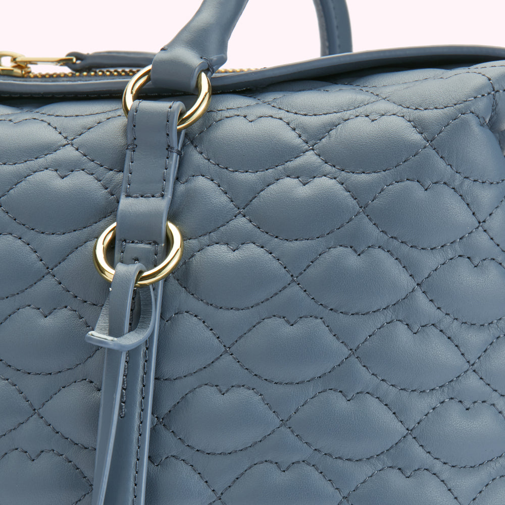 Close-up of a blue quilted leather handbag with gold-toned hardware.