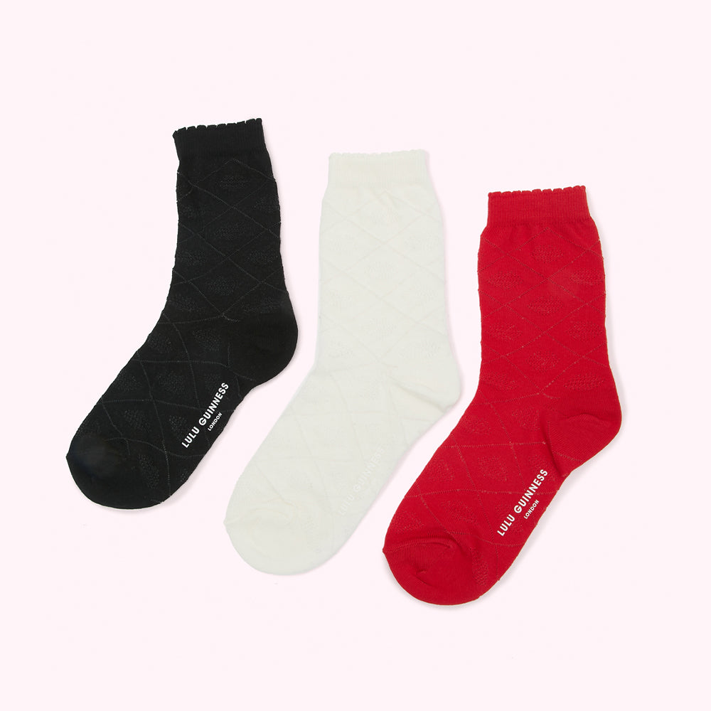 Three pairs of Lulu Guinness socks in black, white, and red, each with a diamond pattern.

