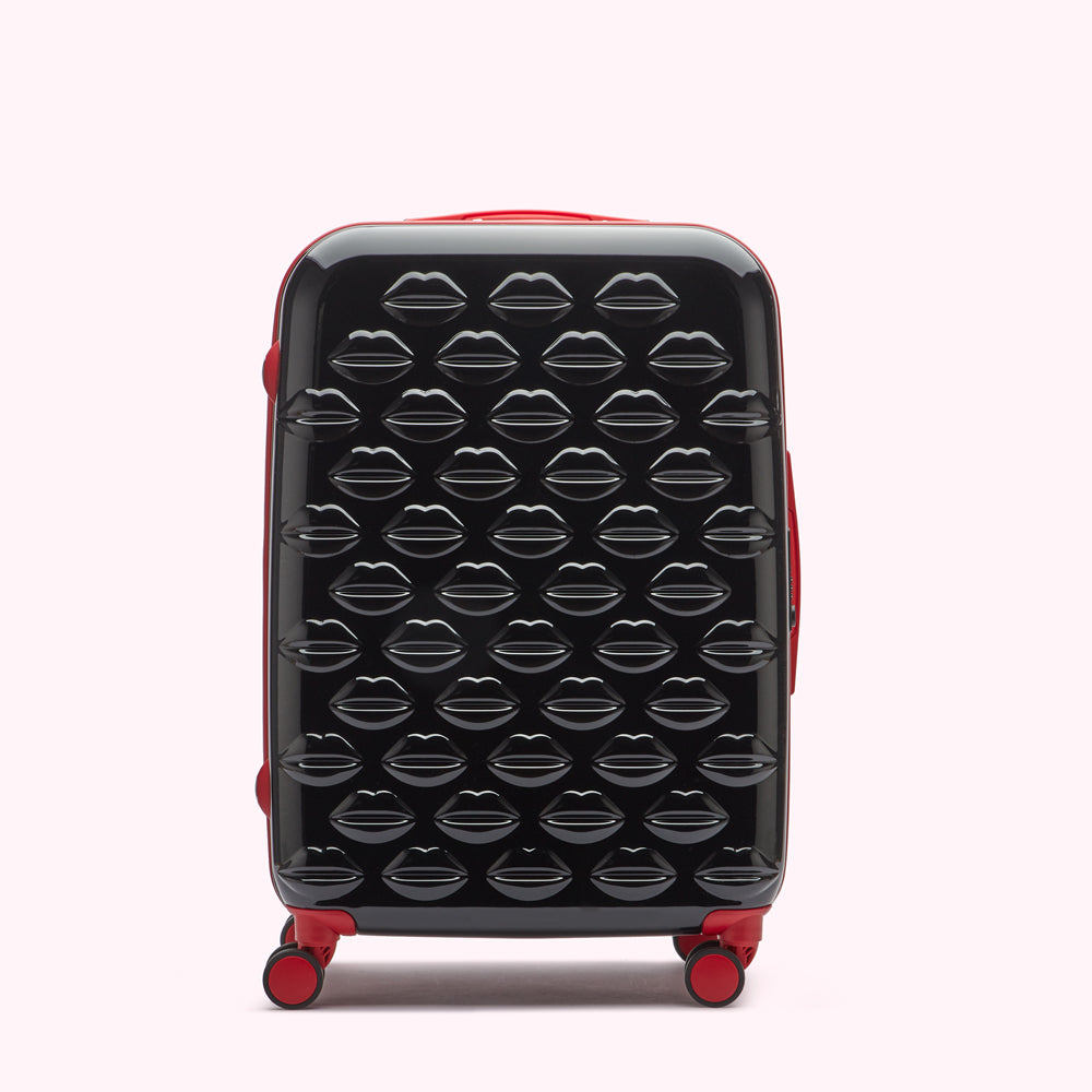 Black suitcase with red accents featuring a lip print pattern.