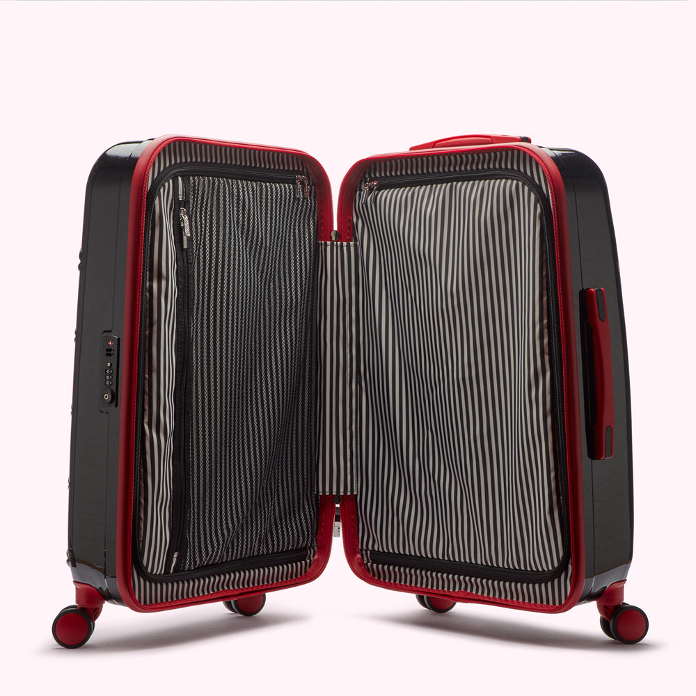 Open red and black suitcase with black and white striped interior lining.
