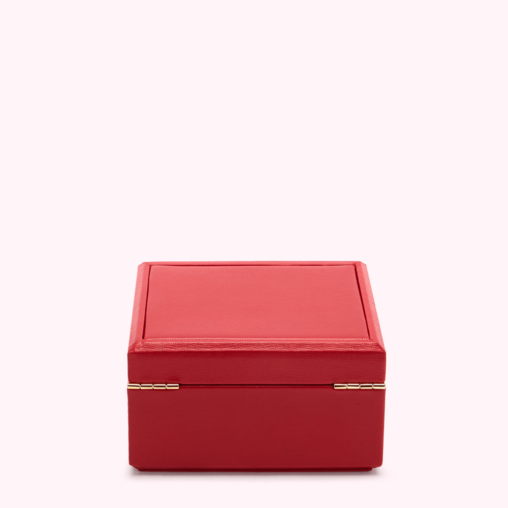 Red rectangular box with gold hinges against a white background.
