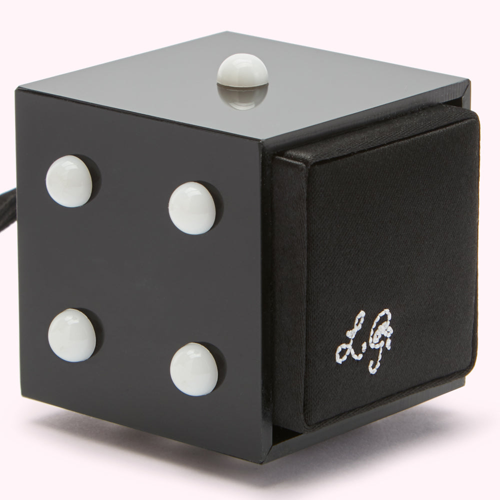 Black cube with white dots on four sides and a black fabric side with embroidered logo.