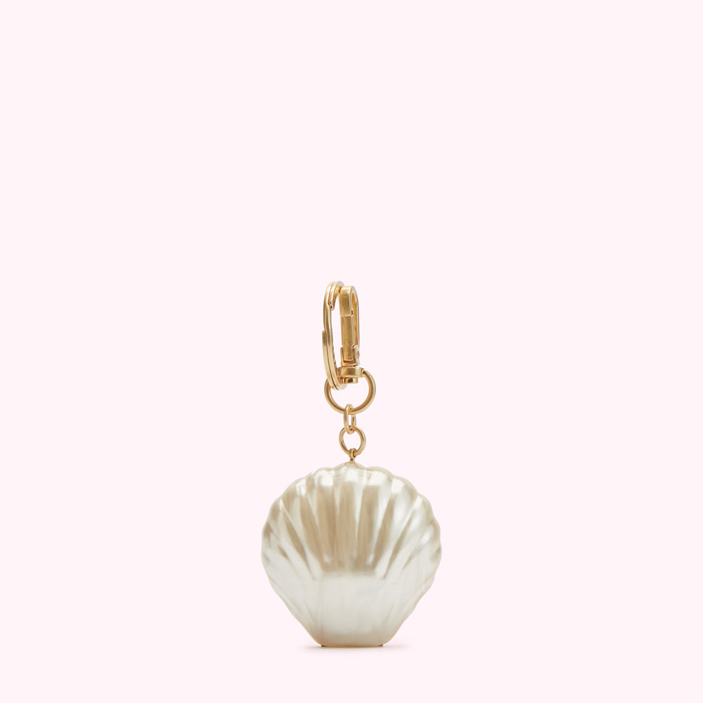 Gold keyring with a pearl seashell charm against a white background.

