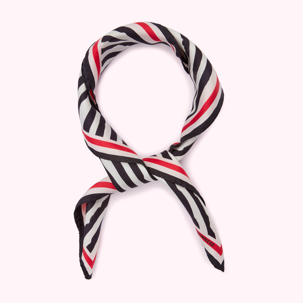 Black and white striped silk scarf with red stripes, knotted.
