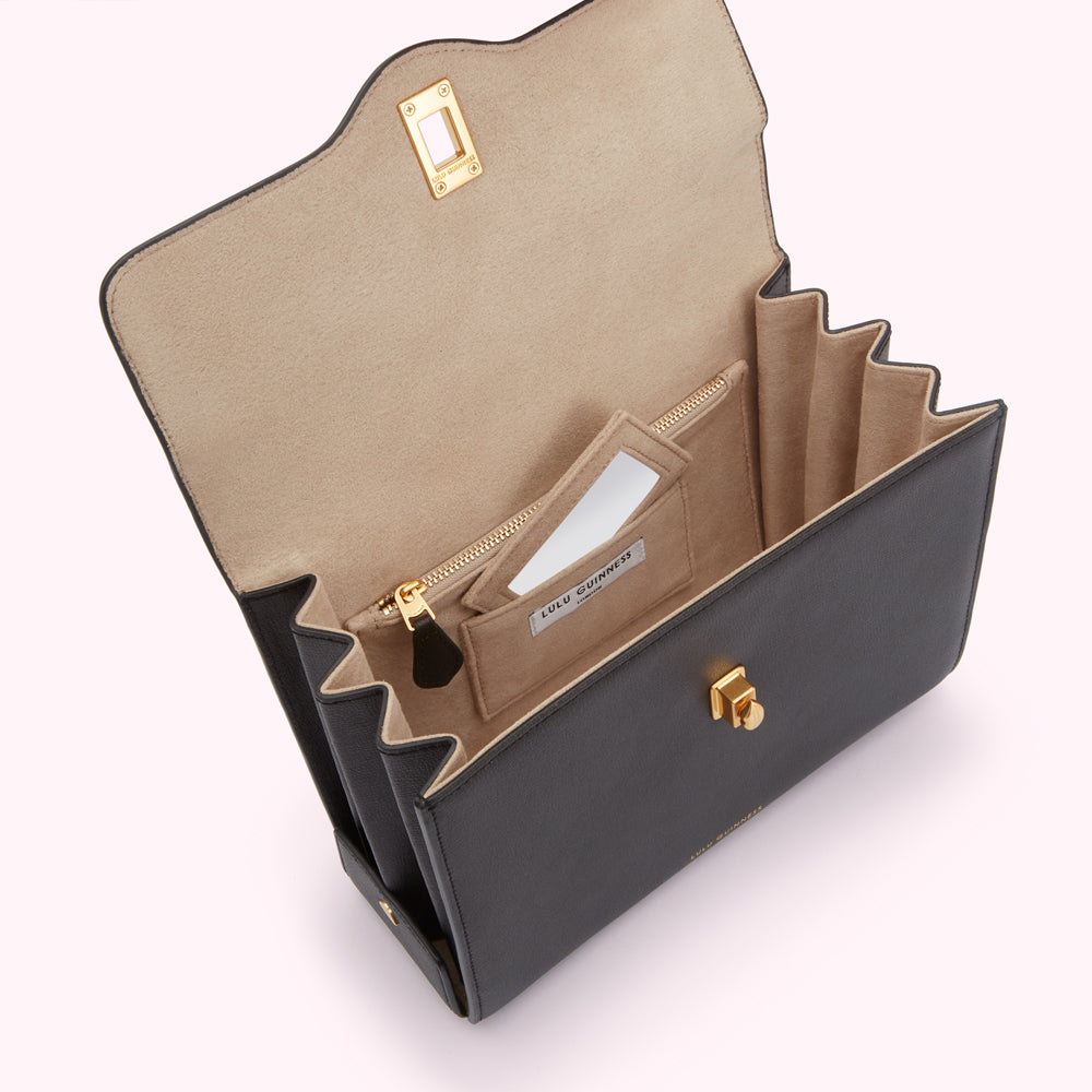 Open black Lulu Guinness handbag with beige interior and gold hardware.