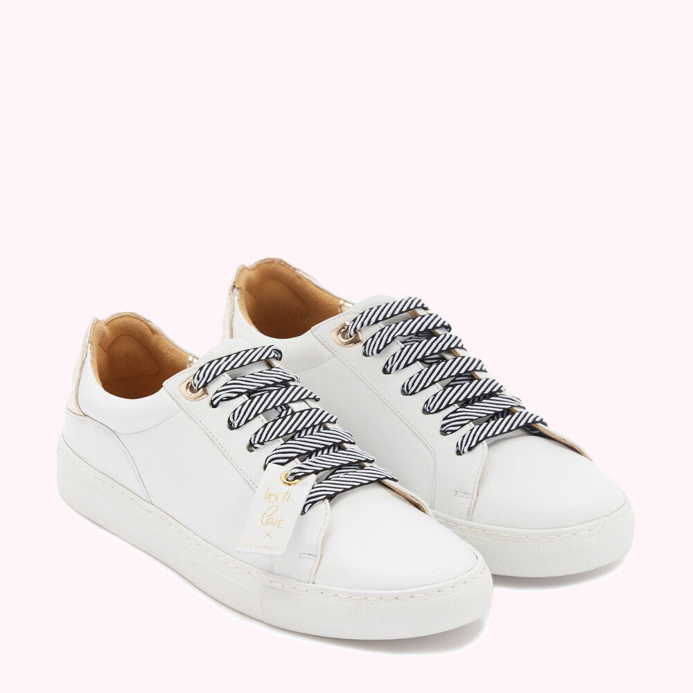 Pair of white leather sneakers with navy and white striped laces and gold accents. A small tag hangs from one lace.
