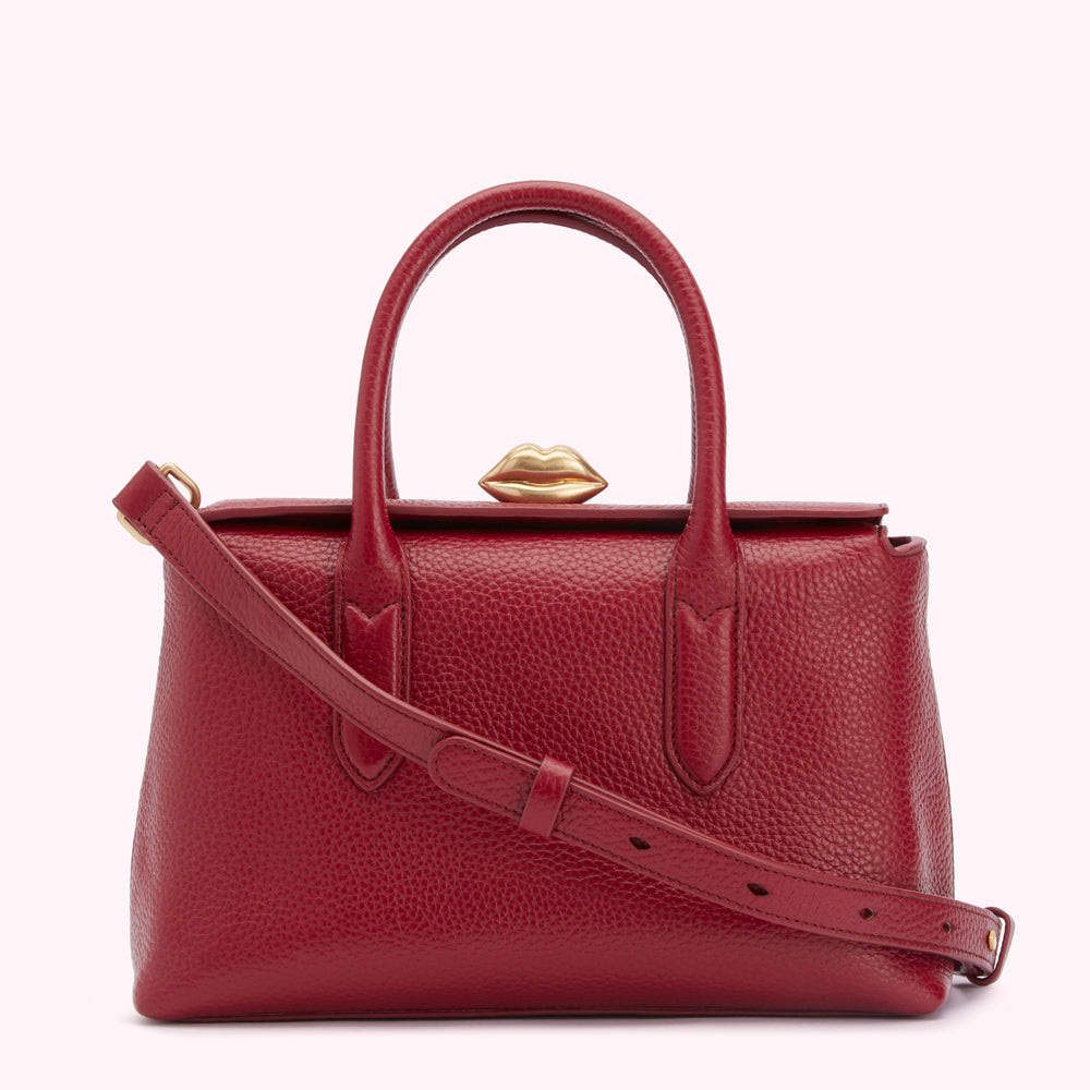 Red leather handbag with gold lip-shaped clasp and detachable shoulder strap.
