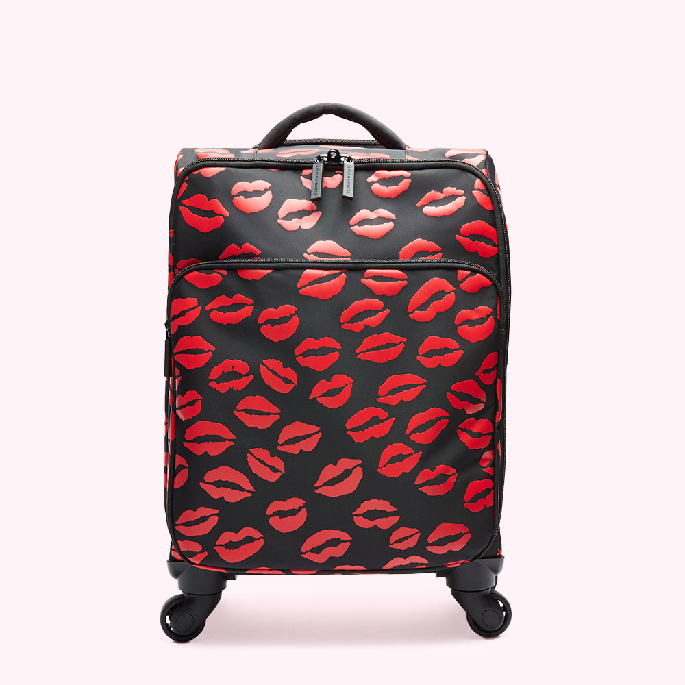 Black carry-on suitcase with red lips print.
