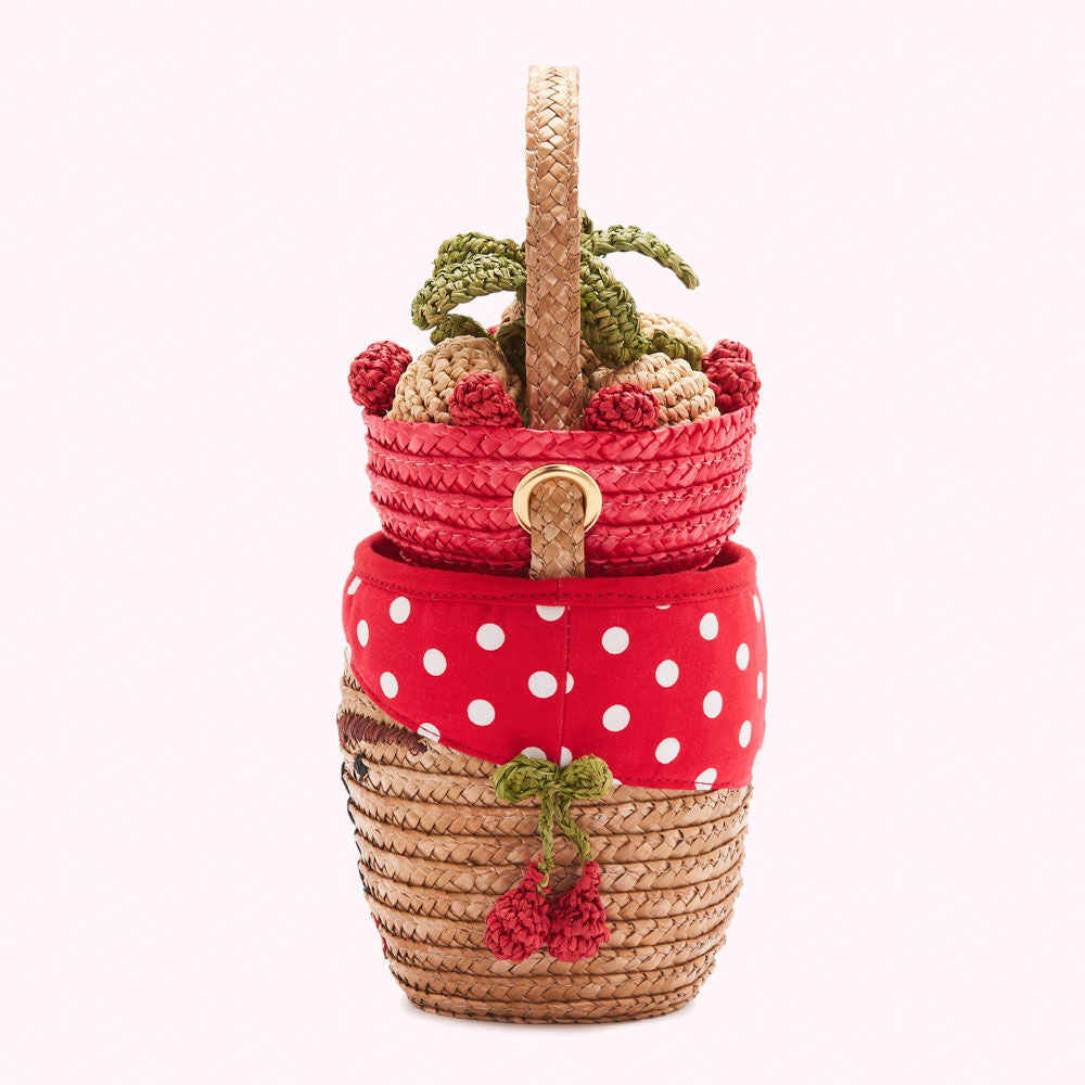 Straw handbag with red polka dot fabric and crocheted cherries.