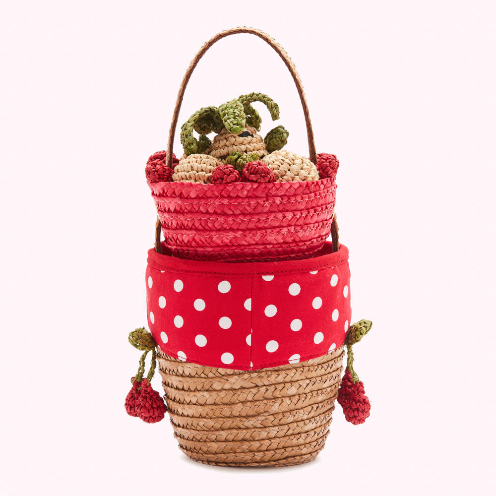 Straw handbag with red polka dot fabric detail and crocheted strawberry accents.