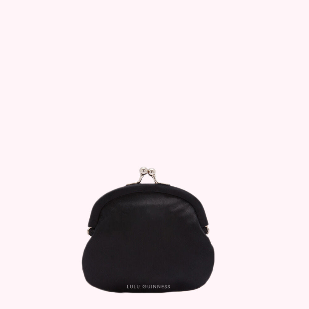 Black Lulu Guinness purse on white background.
