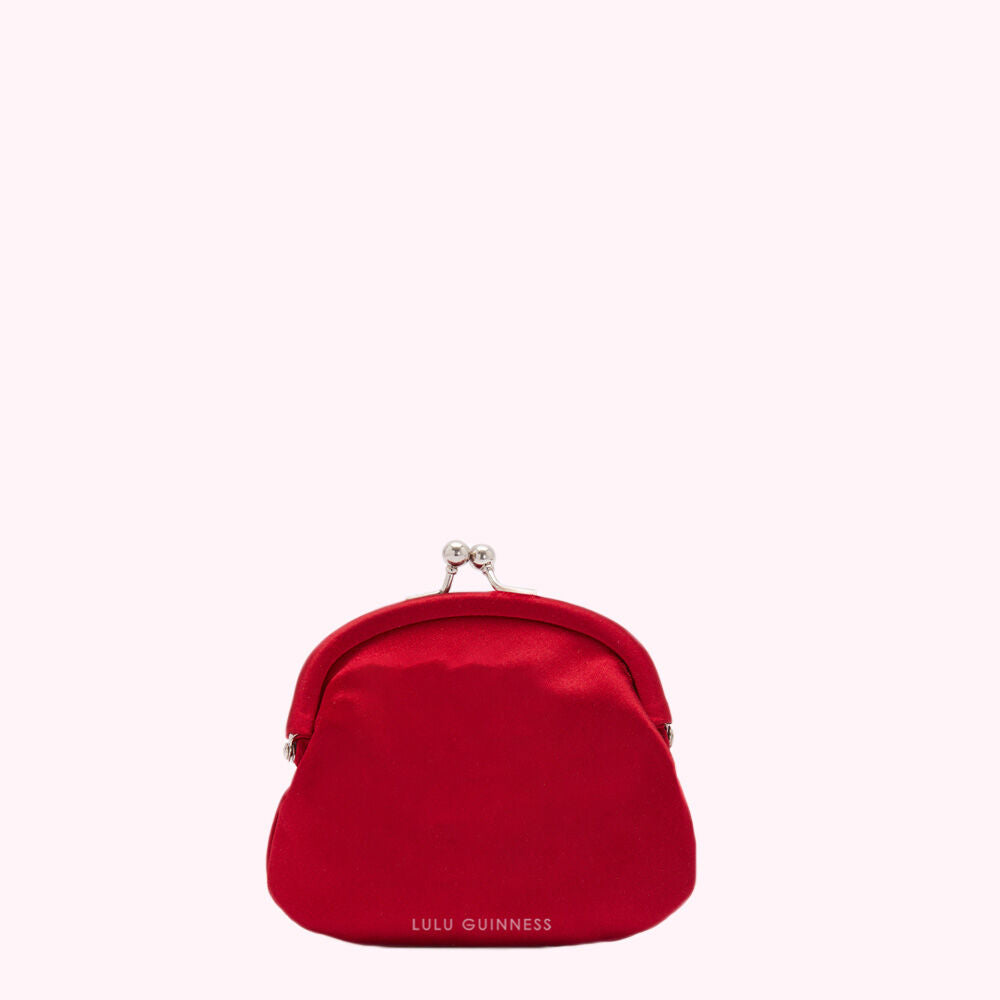 Red Lulu Guinness coin purse on white background.
