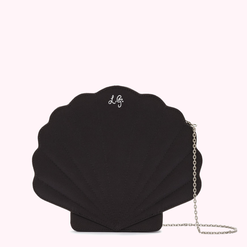 Black seashell-shaped crossbody bag with silver chain strap and subtle logo.
